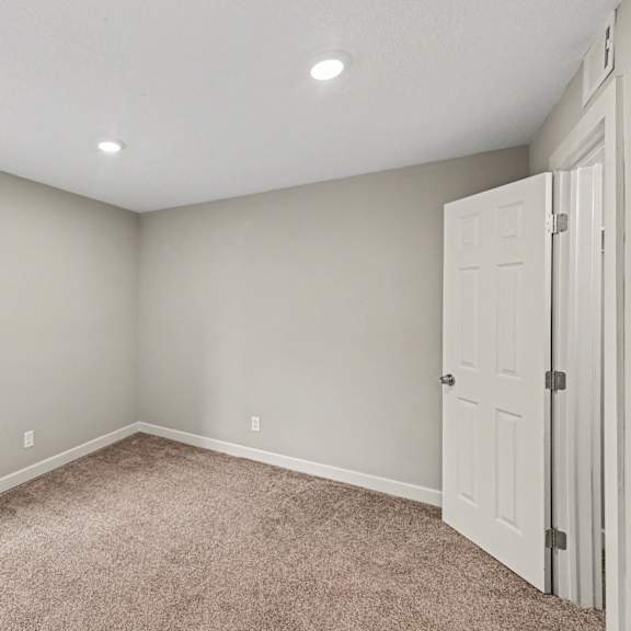 a room with a carpeted floor and a white door.
