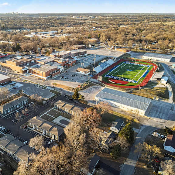 an aerial view of a school with a football field.