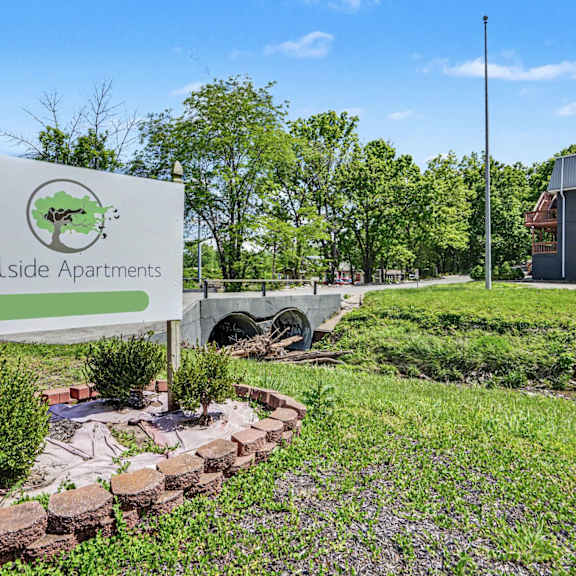a sign for hillside apartments is displayed in front of a building.
