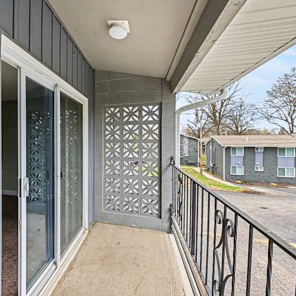 a balcony with a sliding door and a metal railing.