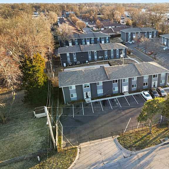 an aerial view of a parking lot and apartment buildings.