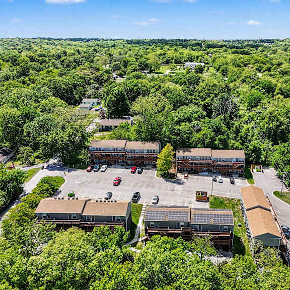 a bird's eye view of a parking lot surrounded by trees and buildings.