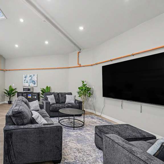 a living room with a grey couch and a black screen at mayfair apartments, missouri, 64145