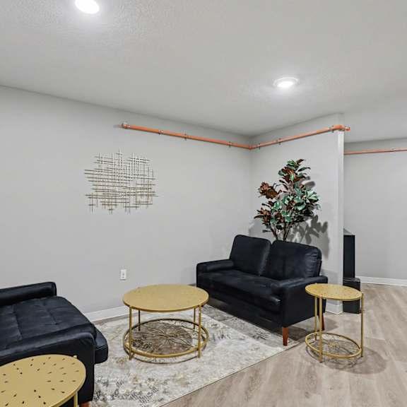 a living room with black leather furniture and a plant at mayfair apartments, apartments, kansas city, mo