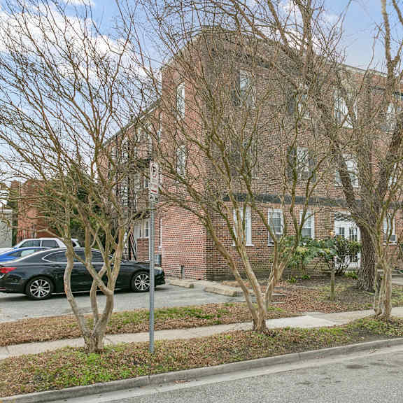 a large brick building with a tree in front of it at shipyard shores apartments, apartments, newport news, va