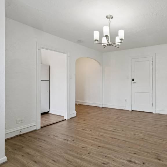 a room with a chandelier and wooden floors. at shipyard shores apartments, newport news, virginia