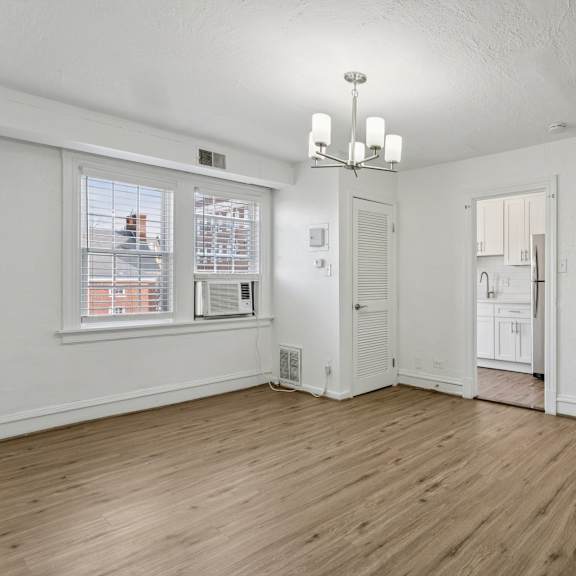 a room with a window, a chandelier, and a wooden floor. at shipyard shores apartments, newport news
