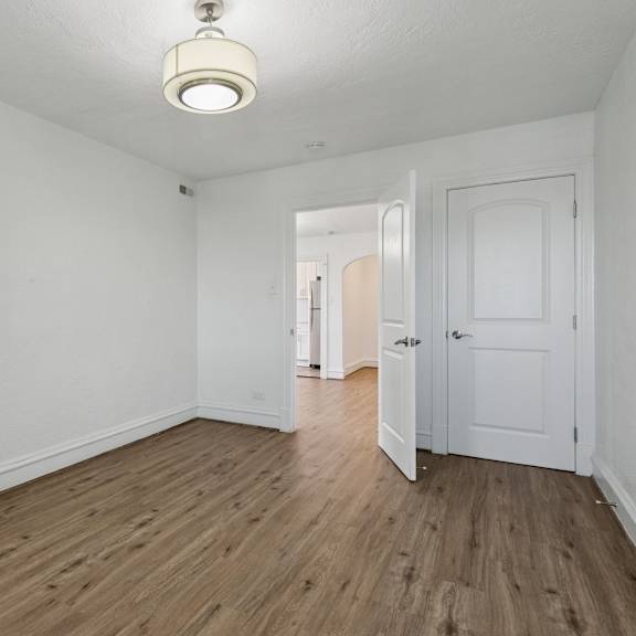 a room with white walls and wooden floors with two doors at shipyard shores apartments, newport news, virginia
