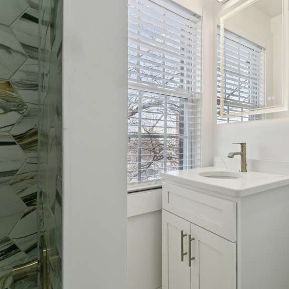 a white bathroom with a sink and a bathtub at shipyard shores apartments, virginia