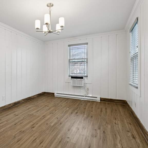 a room with wooden floors and white walls at shipyard shores apartments, virginia