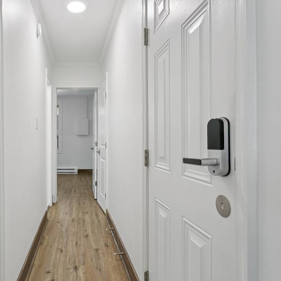a long white hallway with a white door on the right at shipyard shores apartments, newport news, va, 23607