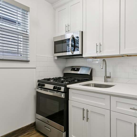 a kitchen with white cabinets and a black stove top oven at shipyard shores apartments, newport news, 23607
