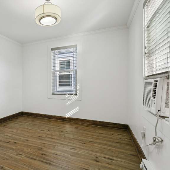 a room with wooden floors and a window with blinds at shipyard shores apartments, newport news