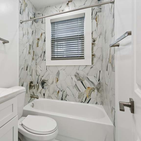 a white bathroom with a marble tile wall at shipyard shores apartments, virginia, 23607