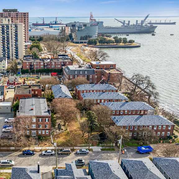 a view of a city with a large body of water and a bridge in the background at shipyard shores apartments, newport news, 23607
