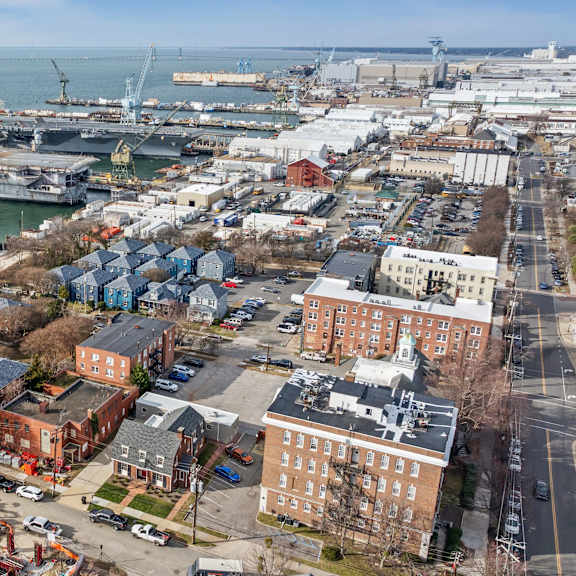 a large ship is docked at a port with several buildings in the foreground at shipyard shores apartments, virginia