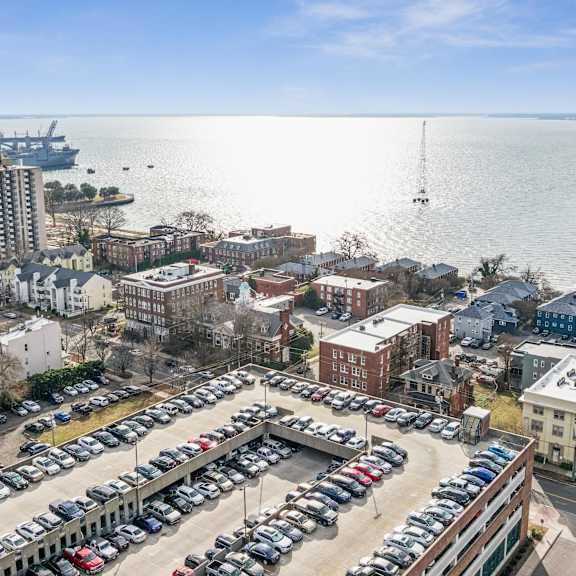 a parking lot with cars and a view of the water at shipyard shores apartments, newport news, virginia