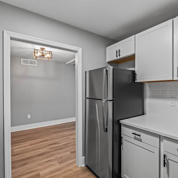 a kitchen with a black fridge and white cabinets. at serenity place central, tallahassee, florida