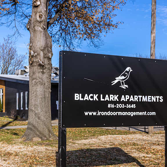 a sign for black lark apartments stands in front of a building. at blacklark apartments, kansas city