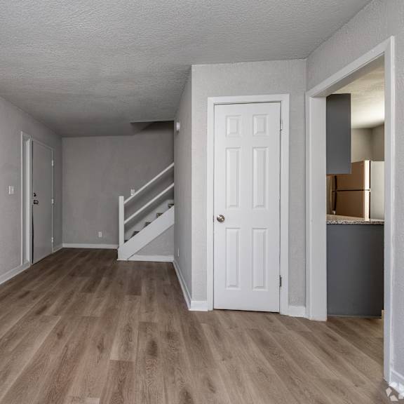 a room with a white door and a staircase leading to another room. at blacklark apartments, kansas city, 66101
