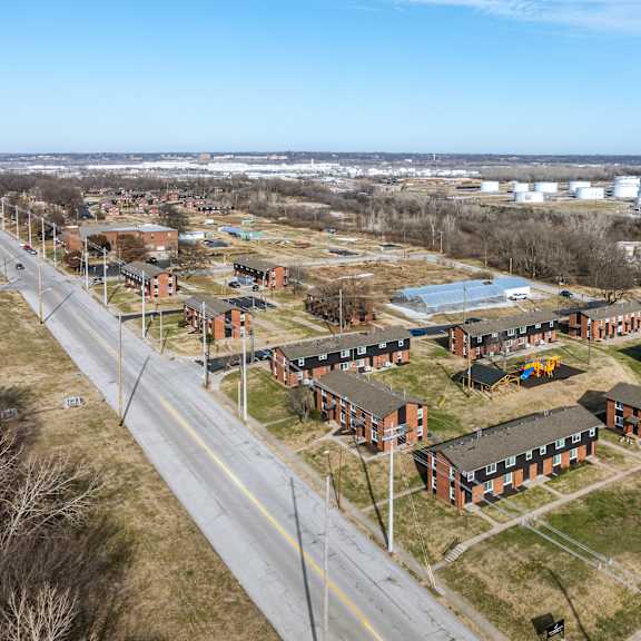 a road runs through a housing development with apartment buildings on either side. at blacklark apartments, apartments, kansas city, ks
