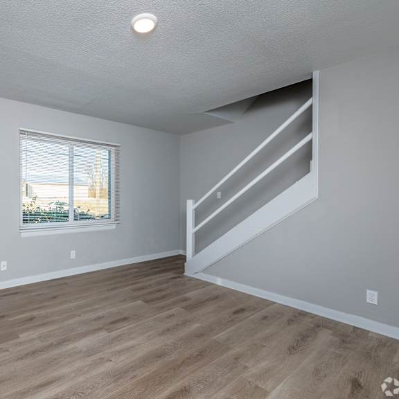 a room with wooden flooring and a window. at blacklark apartments, kansas