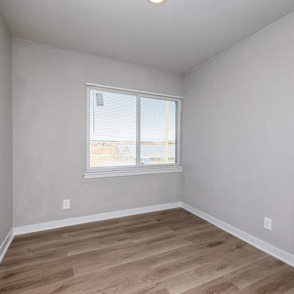 a room with a window and wooden flooring. at blacklark apartments, kansas city, kansas