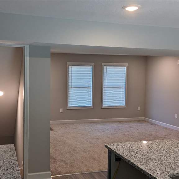 a view from the kitchen of the living room and staircase downstairs