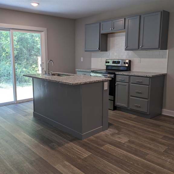 an empty kitchen with an island in the middle