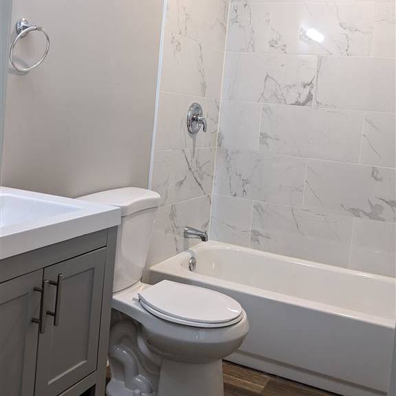 a bathroom with a toilet and a tub and a sink