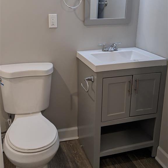 a bathroom with a toilet, a sink and a mirror