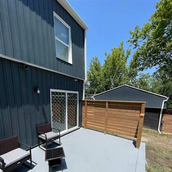 a patio with a fence and chairs on it