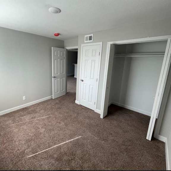a bedroom with carpet floor and a closet