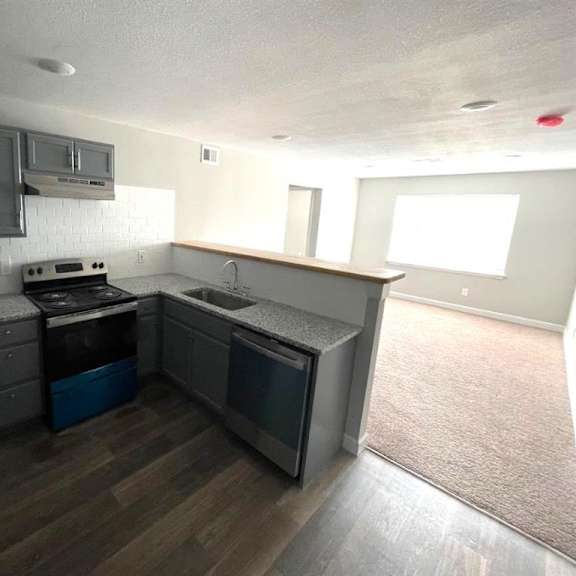 an empty kitchen with a stove and a refrigerator