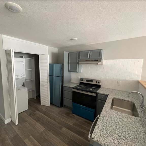 a kitchen with a sink and a stove and a refrigerator