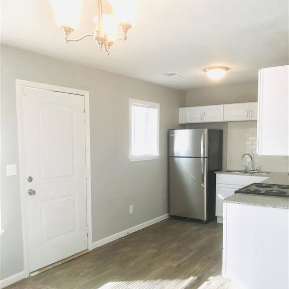 kitchen view with a refrigerator, stove, and sink