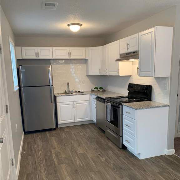 a full kitchen view with white cabinets and a stainless steel appliances