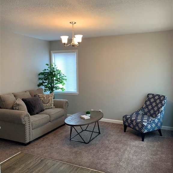 a living room with a couch, a chair and a table