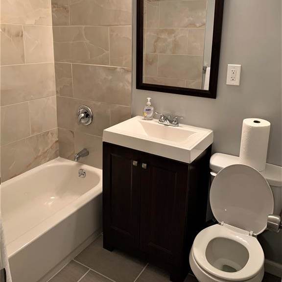a bathroom with a toilet, a sink and a bath tub