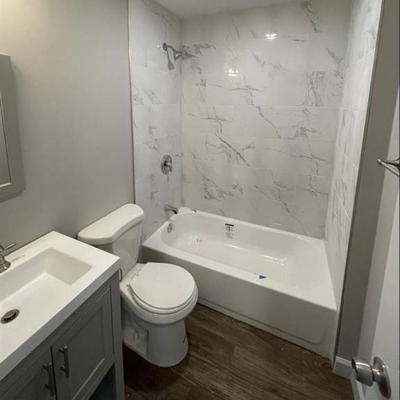 a bathroom with a toilet and a tub and a sink