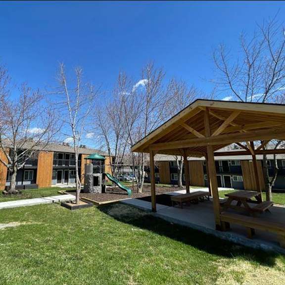 a playground with a pavilion in front of a building