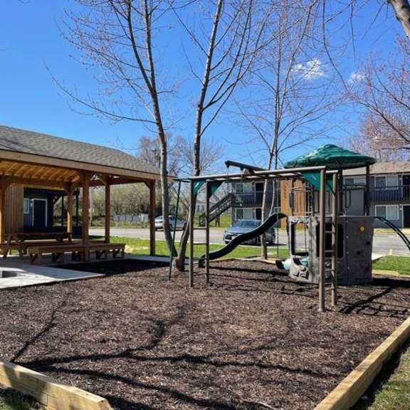 a playground with a swing set and a pavilion