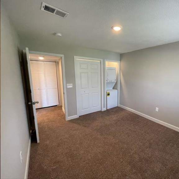 an empty room with a washer and dryer in a closet