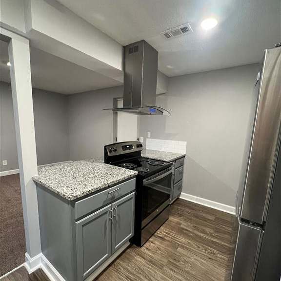 a kitchen with stainless steel appliances and a wood floor