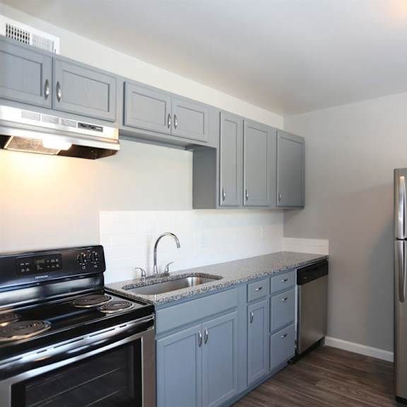 a kitchen with stainless steel appliances and white cabinets