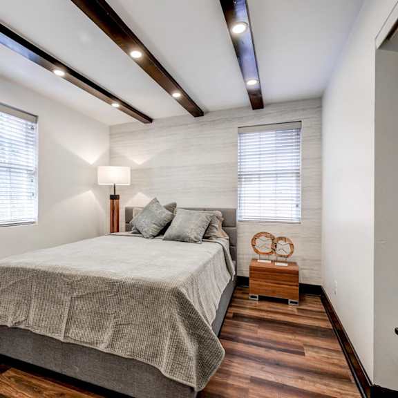 bedroom with exposed wood beams and accent wall at the tuscan hills ahr llc apartments, maryland