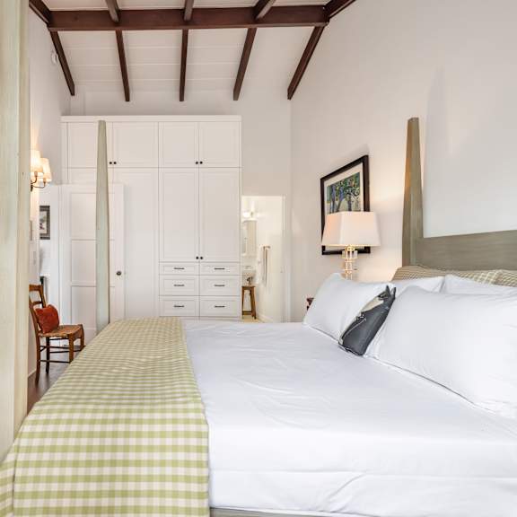 a bedroom with a bed, a chair, and a lamp.