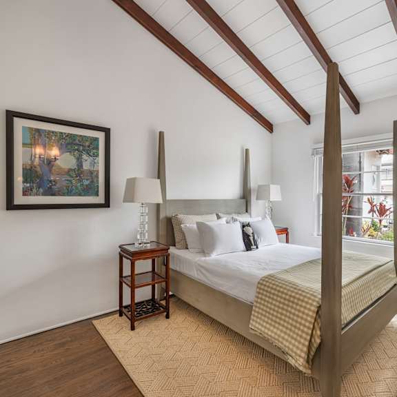 a bedroom with a bed, nightstand, and lamp.
