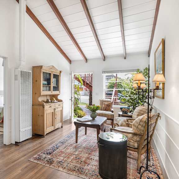 a living room with a wooden floor and white walls.