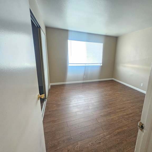 a room with wooden flooring and a window.